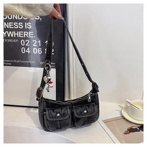 Detail of washed black denim Y2K shoulder bag with utility pockets and heart charms