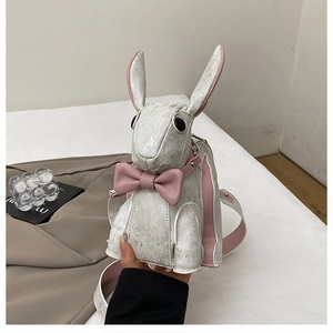 Detail of cute white rabbit shoulder bag with silver texture, pink bow and adjustable strap