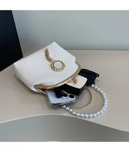 Detail view of the pearl handle shell bag interior with textured white leather finish