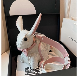 Unboxing detail of a cute 3D bunny shaped crossbody bag in a gift box with a wide strap