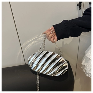 Detail view of silver metallic shell bag with elegant wavy pleats and fine chain strap