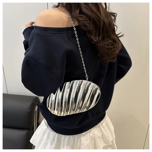 Detail view of the silver metallic ripple shell crossbody bag with metal chain strap