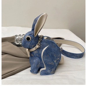Detail of blue rabbit crossbody bag featuring vintage denim texture and gold foil texture