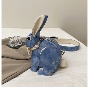 Close-up of rabbit-shaped crossbody bag featuring blue denim texture and silver zipper