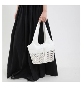 Detail of white patent leather shoulder bag with silver studs and polished mirror finish