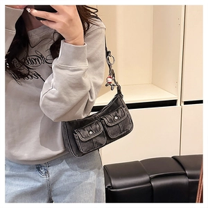 Mirror selfie showing a grey denim cargo shoulder bag with multiple pockets and a cute charm