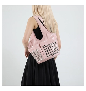 Rear view of a model wearing a punk pink patent leather tote bag with silver studs