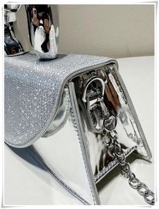 Detail of silver mirror handbag with rhinestone flap and metallic sculptural handle