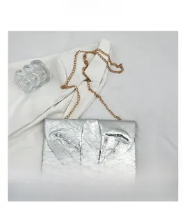 Vue détaillée de la texture argentée froissée et de la chaîne dorée du sac pochette