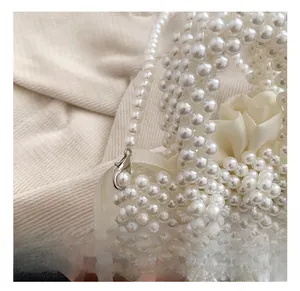 Détail du crochet en métal argenté et doublure en satin blanc du sac à main perlé