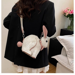 Detail of cute white bunny crossbody bag with pink accents shown in a home setting