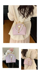Detail of pink shell bag featuring pearl handle, gold hardware, and metal tassels