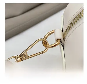 Vue macro des ferrures dorées de qualité et du cuir grainé sur un sac à main chic