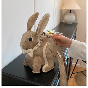 Detail of cute gold bunny crossbody bag with glitter finish and elegant bow decoration