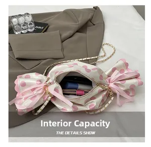 Detail view of pink polka dot candy bag interior showing storage space and gold chain