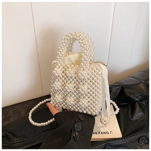 Detail of handmade pearl bead handbag showing woven texture and glossy satin drawstring liner