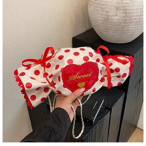 Close-up of heart embroidery with Sweet text and red bows on polka dot candy bag
