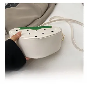 Gros plan du fond durable du sac à bandoulière en cuir blanc en forme de fraise