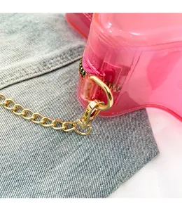 Détail du crochet doré amovible et de la chaîne métallique du sac rose transparent