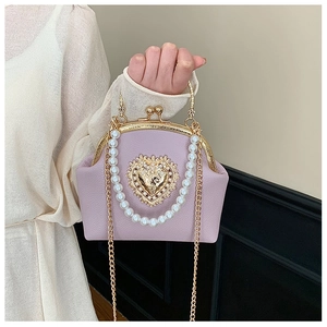 Macro shot of light purple retro shell bag with gold heart ornament and pearl handle