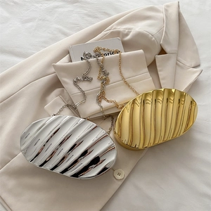 Elegant gold and silver shell-shaped metallic evening bags with wavy texture and chain strap