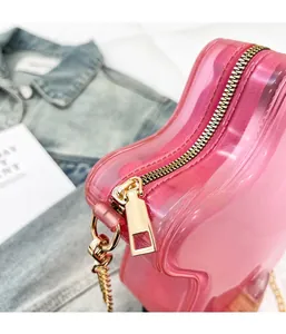 Détail de la fermeture éclair en métal doré sur un mini sac à bandoulière rose translucide
