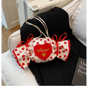 Detail of candy-shaped crossbody bag with red polka dots and sweet heart embroidery