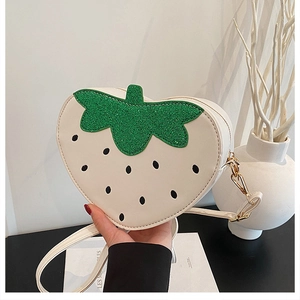 Détail du sac à main créatif en forme de fraise crème avec accent de feuille pailletée