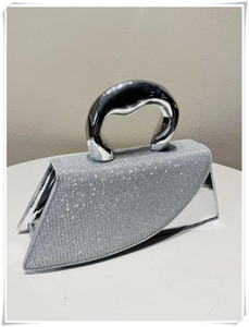 Macro shot of sparkling silver glitter texture and thick metallic handle on square handbag
