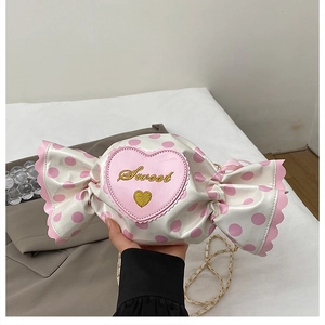 Detail view of heart-shaped candy crossbody bag with pink polka dots and gold chain