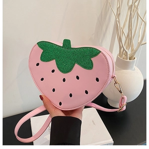 Détail du sac fraise rose avec des feuilles vertes pailletées et des crochets dorés