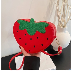 Détail du sac à bandoulière en forme de fraise rouge en cuir PU avec feuilles brillantes