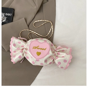 Detail of candy-shaped crossbody bag with pink polka dots and Sweet heart embroidery