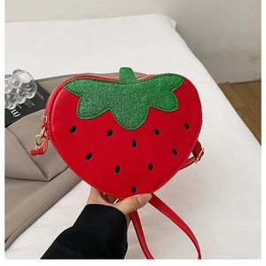 Détail du sac fraise en cuir rouge avec pois noirs et feuilles en paillettes vertes