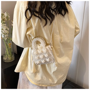 Detail of white handmade pearl beaded handbag with satin drawstring liner and side bows