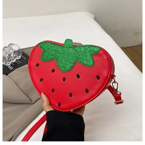 Détail du sac fraise avec feuilles en paillettes vertes et texture en similicuir rouge