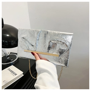 Détail de la pochette argentée effet froissé avec garniture dorée et fine bandoulière