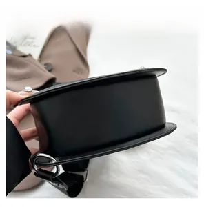 Close-up of the sturdy base and silver metal rings on this guitar-shaped black leather bag