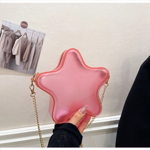 Détail du sac bandoulière rose transparent en forme d'étoile avec chaîne dorée