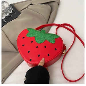 Détail du sac à main fraise rouge avec feuilles de paillettes vertes et zip doré