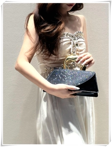 Detail of luxury black evening clutch with sparkling sequins and gold fluid handle