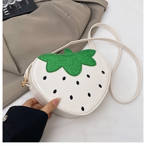 Détail du sac fraise en similicuir blanc avec des feuilles décoratives en paillettes