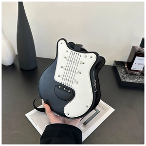 Detail of guitar-shaped crossbody bag featuring metallic rivets and black-white PU leather