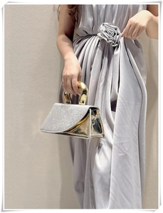 Detail of silver rhinestone evening bag with elegant golden U-shaped metal handle
