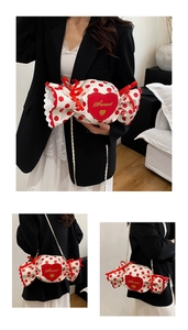 Detail of candy-shaped crossbody bag with red polka dots and sweet heart embroidery