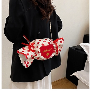 Detail of candy-shaped white crossbody bag with red polka dots and sweet embroidery
