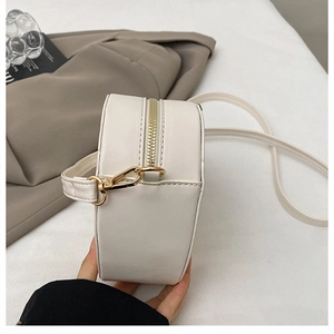 Vue détaillée du sac bandoulière blanc en cuir PU avec fermeture éclair dorée et coutures
