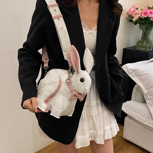 Cute white bunny crossbody bag with pink bow accents and textured leather on female model