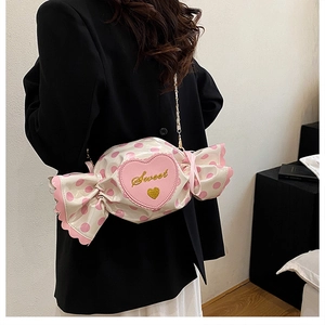 Detail view of pink candy-shaped crossbody bag with sweet heart embroidery and chain strap