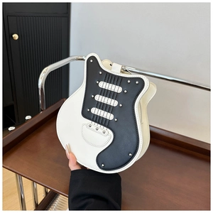 Detailed close-up of a guitar-shaped crossbody bag with metal rivets and black-white PU leather
